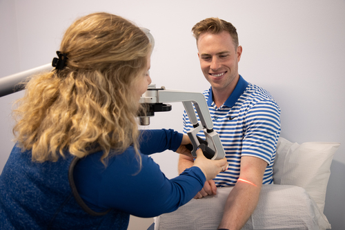 A man receiving laser therapy from a chiropractor in Ann Arbor