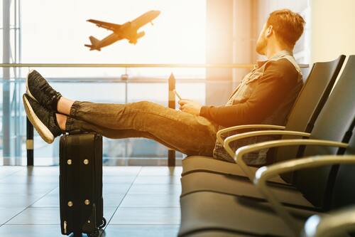 A man in an airport watching a plane take off | Chiropractors Ann Arbor