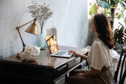 A woman sitting at a desk with good posture | Chiropractor near me