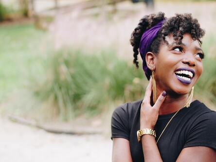 A woman holding her neck comfortably while smiling | Neck adjustment Ann Arbor